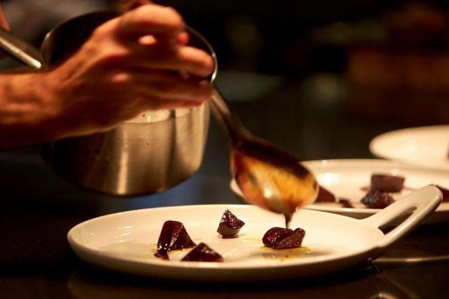 a person holding a spoon over a plate of food at Thon Hotel Vettre in Asker