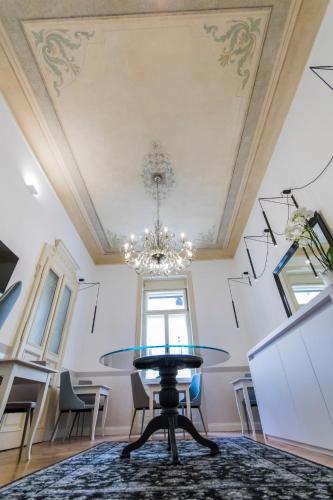 a dining room with a table and a chandelier at Residenza Degli Artisti in Trieste