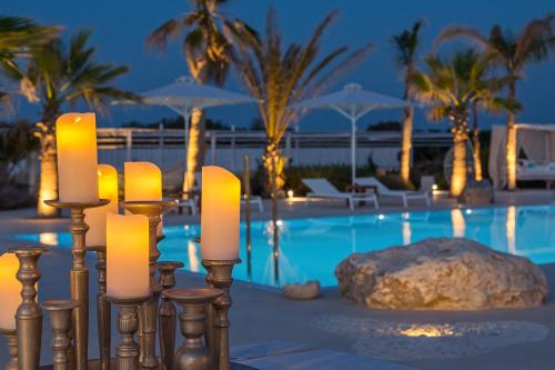 un grupo de velas frente a una piscina en White Pearls-Adults Only Luxury Suites en Cos