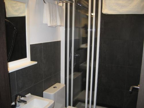une salle de bain avec une douche, des toilettes et un lavabo dans l'établissement Suites Coruña, à La Corogne