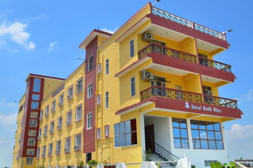 a yellow building with red balconies on it at Hotel Bodh Vilas in Bodh Gaya