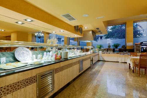 a restaurant with a buffet line with tables at Senator Granada in Granada