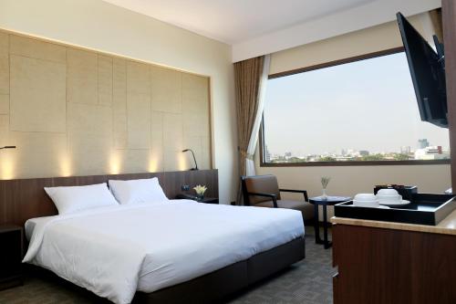 a hotel room with a bed and a large window at Louis Tavern Hotel in Bangkok