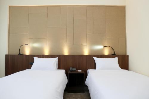 two beds sitting next to each other in a hotel room at Louis Tavern Hotel in Bangkok