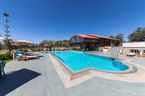 a swimming pool with tables and chairs next to a building at Traldi Resort in Vetralla