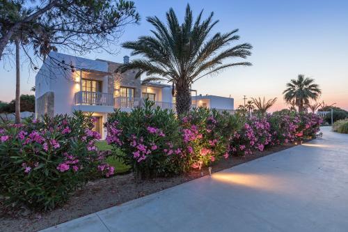 a house with a palm tree and purple flowers at White Pearls-Adults Only Luxury Suites in Kos Town