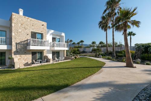 a house with palm trees and a walkway at White Pearls-Adults Only Luxury Suites in Kos Town