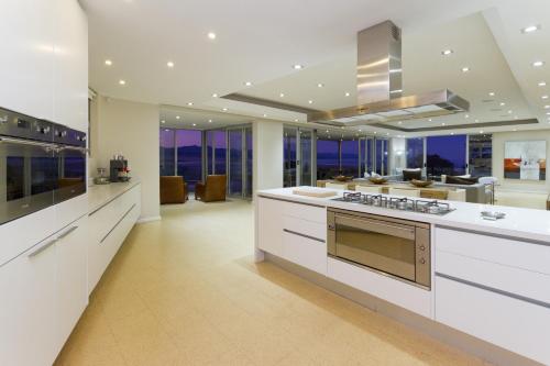a large kitchen with white cabinets and a stove at No1 Sangaree in Plettenberg Bay