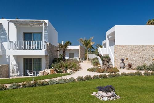 a white house with a garden and a lawn at White Pearls-Adults Only Luxury Suites in Kos Town