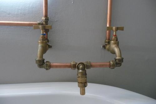 a pair of copper pipes on top of a toilet at Avonsrus Guesthouse in Augrabies
