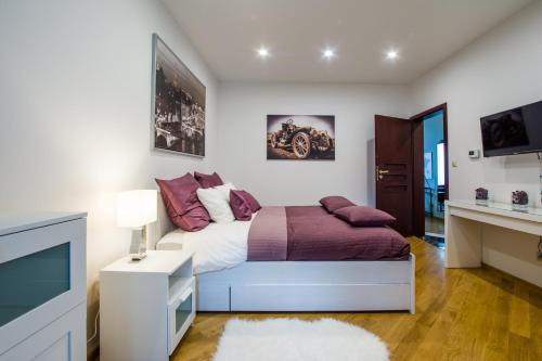 a bedroom with a bed and a flat screen tv at Apart Madryt in Tarnobrzeg