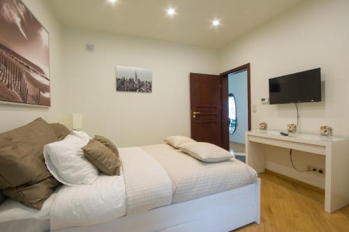 a bedroom with a bed and a desk and a television at Apart Madryt in Tarnobrzeg