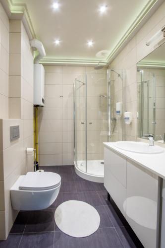 a bathroom with a toilet and a sink and a tub at Apart Madryt in Tarnobrzeg