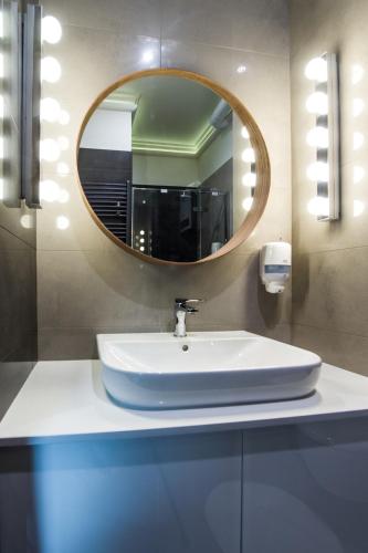 a bathroom with a sink and a mirror at Apart Madryt in Tarnobrzeg
