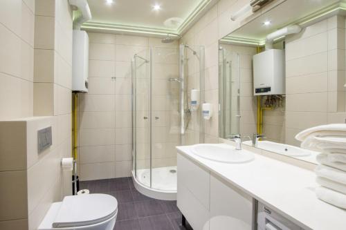 a bathroom with a toilet and a sink and a shower at Apart Madryt in Tarnobrzeg