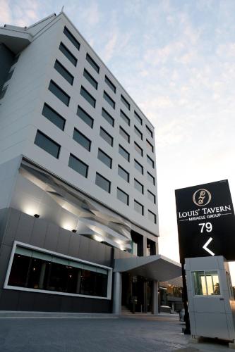 a hotel building with a sign in front of it at Louis Tavern Hotel in Bangkok