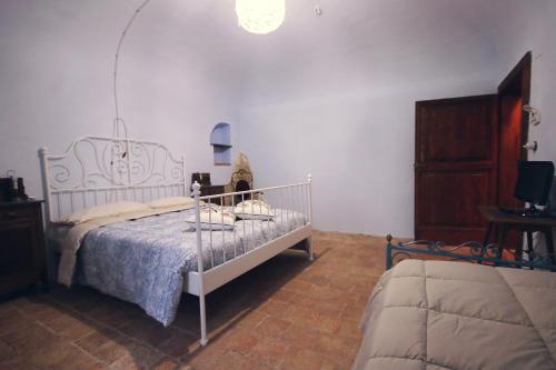 a bedroom with a white bed with a blue blanket at Al Casolare in Ofena