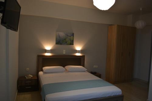 a bedroom with a bed with two pillows and a television at Thegaia Studios in Rethymno Town