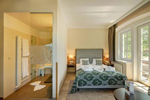 1 dormitorio con cama y espejo grande en Hotel Schneeberghof, en Puchberg am Schneeberg