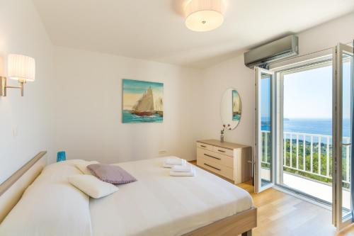 a bedroom with a large bed and a balcony at Hedera Estate, Villa Hedera VII in Zaton