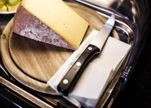 a knife on a plate with cheese and meat at Hotel Tum Stüürmann in Büsum