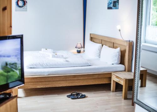 a bedroom with a bed and a flatscreen tv at Hotel Tum Stüürmann in Büsum