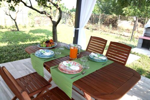 a table with a green table cloth and a bowl of fruit at SOHO Suite in Fisciano