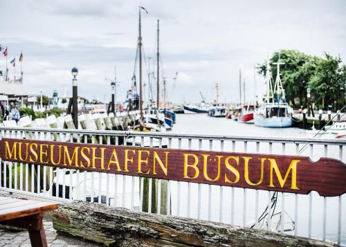 a marina with a wooden sign that reads musswegian eighteenbush at Hotel Tum Stüürmann in Büsum