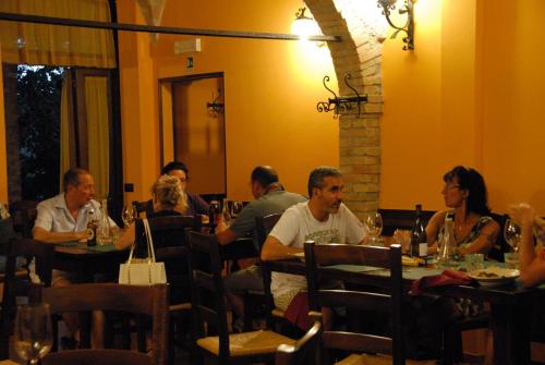 a group of people sitting at tables in a restaurant at Agriturismo Il Giardino Dei Ciliegi in Passaggio Di Assisi