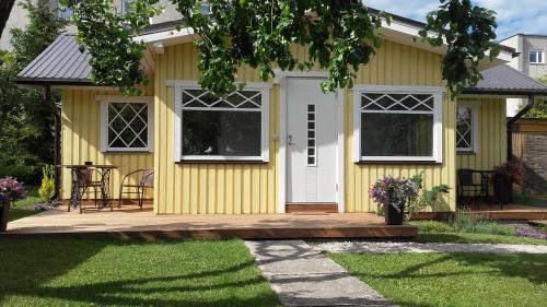a yellow house with a white door at Haavalehe Summer House in Haapsalu