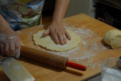 a person making a dough on a cutting board at Agriturismo Il Giardino Dei Ciliegi in Passaggio Di Assisi