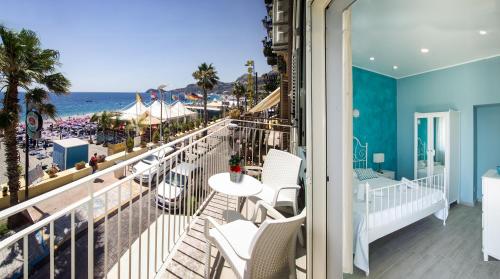 balkon z białymi krzesłami i widokiem na plażę w obiekcie Ciao Ciao Rooms w mieście Letojanni