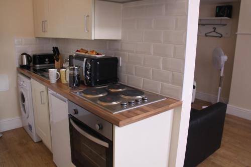 a kitchen with a stove top oven next to a microwave at The Trafford in Stockport