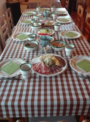 a table with plates of food on a checkered table cloth at Csodaszarvas Vendégházak in Rábahidvég
