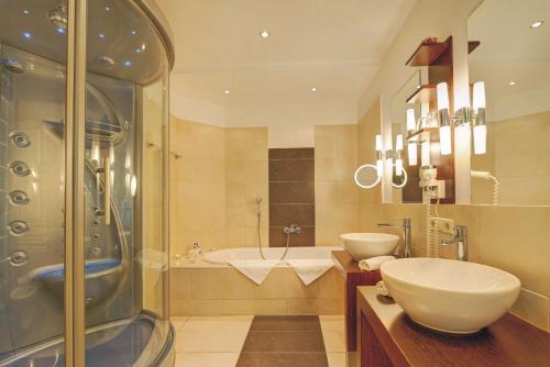 a bathroom with two sinks and a shower at Hotel Schneeberghof in Puchberg am Schneeberg