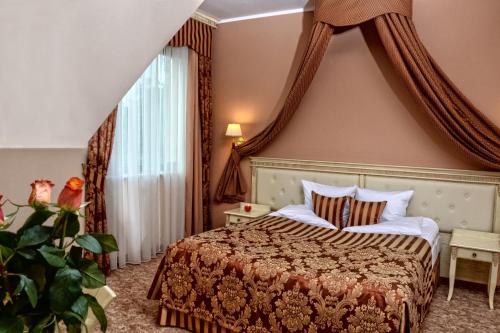 a hotel room with a bed and a window at Hotel Ventus Natural & Medical Spa in Gołdap