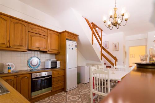a kitchen with wooden cabinets and a white refrigerator at Athena Villas Olive Grove & Estate in Gouves