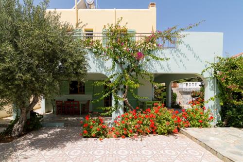 a house with flowers in front of it at Athena Villas Olive Grove & Estate in Gouves