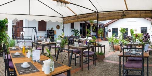 un ristorante con tavoli e sedie sotto una tenda di Cold River a Luang Prabang