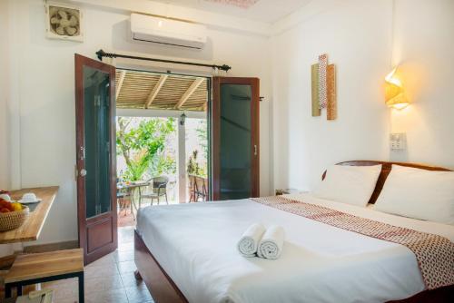 ein Schlafzimmer mit einem Bett mit zwei weißen Handtüchern darauf in der Unterkunft Cold River in Luang Prabang