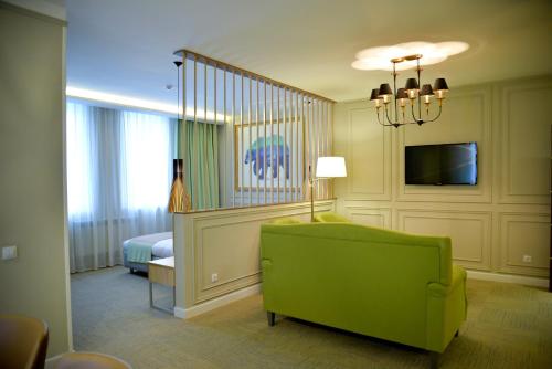 a living room with a green couch and a bed at GREEN Which Hotel in Kokshetau