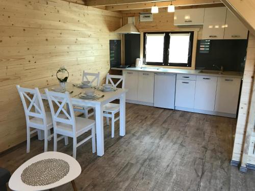 a kitchen and dining room with a table and chairs at Domki na Morskiej in Łukęcin