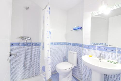 baño azul y blanco con aseo y lavamanos en Residencial Plaza Mayor, en Calpe