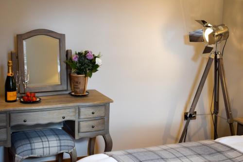 a dressing table with a mirror and flowers on it at Benoch Lomond Castle in Alexandria