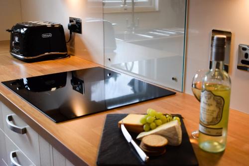 a counter with a bottle of wine and a plate of food at Benoch Lomond Castle in Alexandria