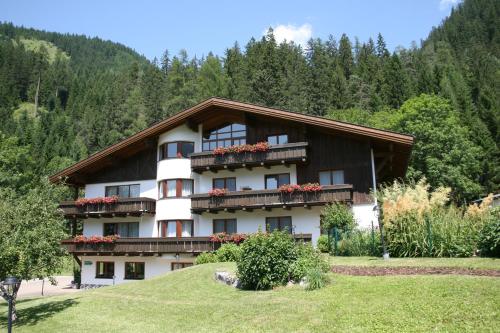 a building with flowers on the balconies on a hill at Haus Montana in Elbigenalp