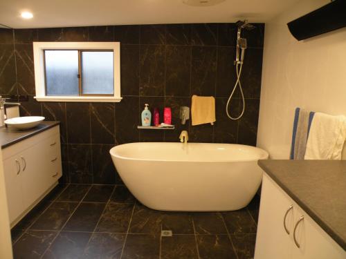 a bathroom with a bath tub and a window at The Anchorage Cottage Kangaroo Island in American River