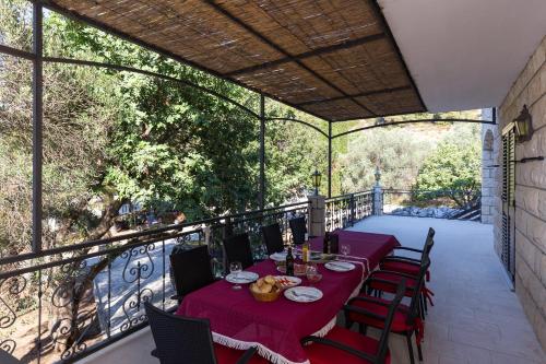 a patio with a table and chairs on a balcony at Rooms Villa Bašica in Saplunara