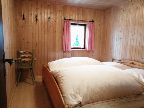 ZellbergにあるAlmhütte Söggenのベッドルーム1室(ベッド1台、窓、椅子付)