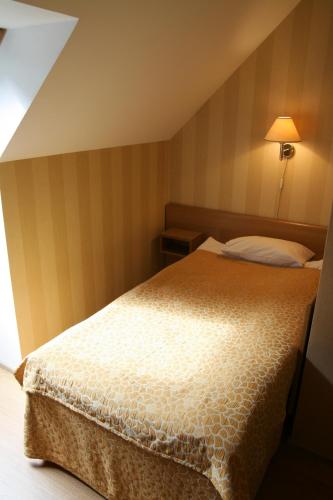 a bedroom with a bed and a lamp on a wall at Barclay Hotel in Tartu